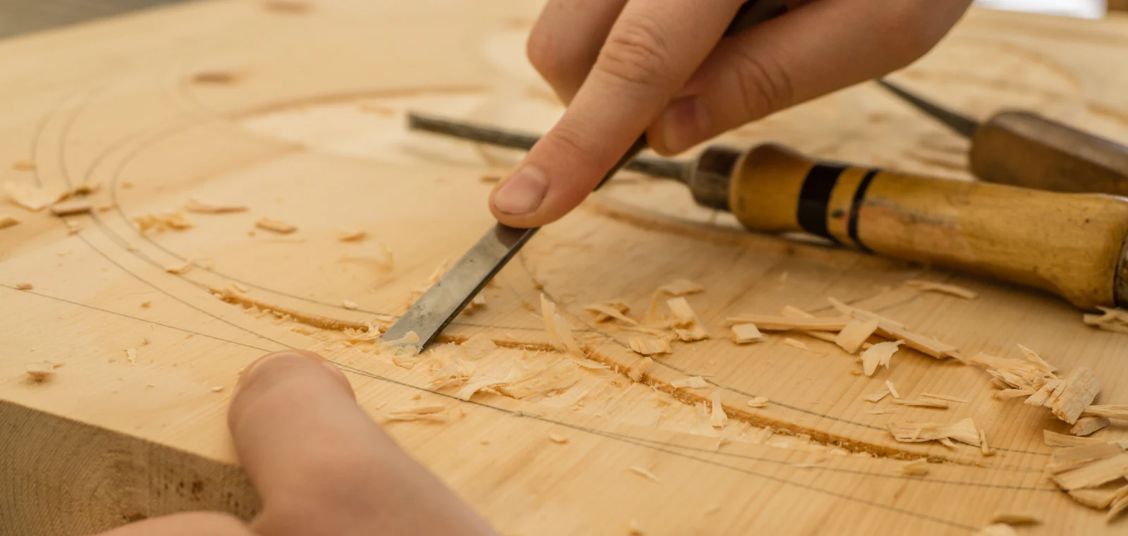 Menuisier sculptant une pièce de bois au ciseau à l’atelier