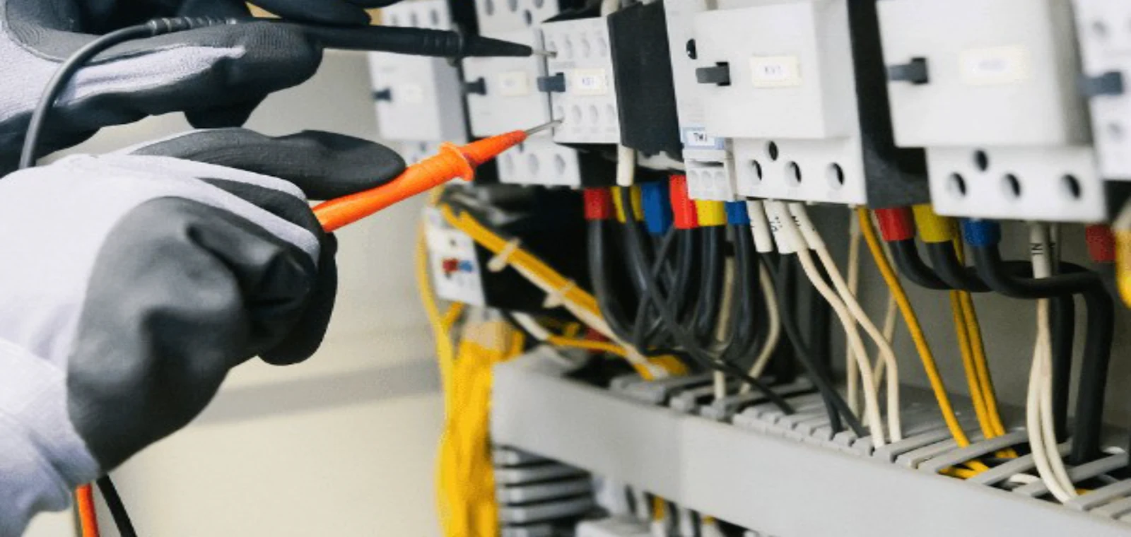 Électricien contrôlant un tableau électrique au multimètre